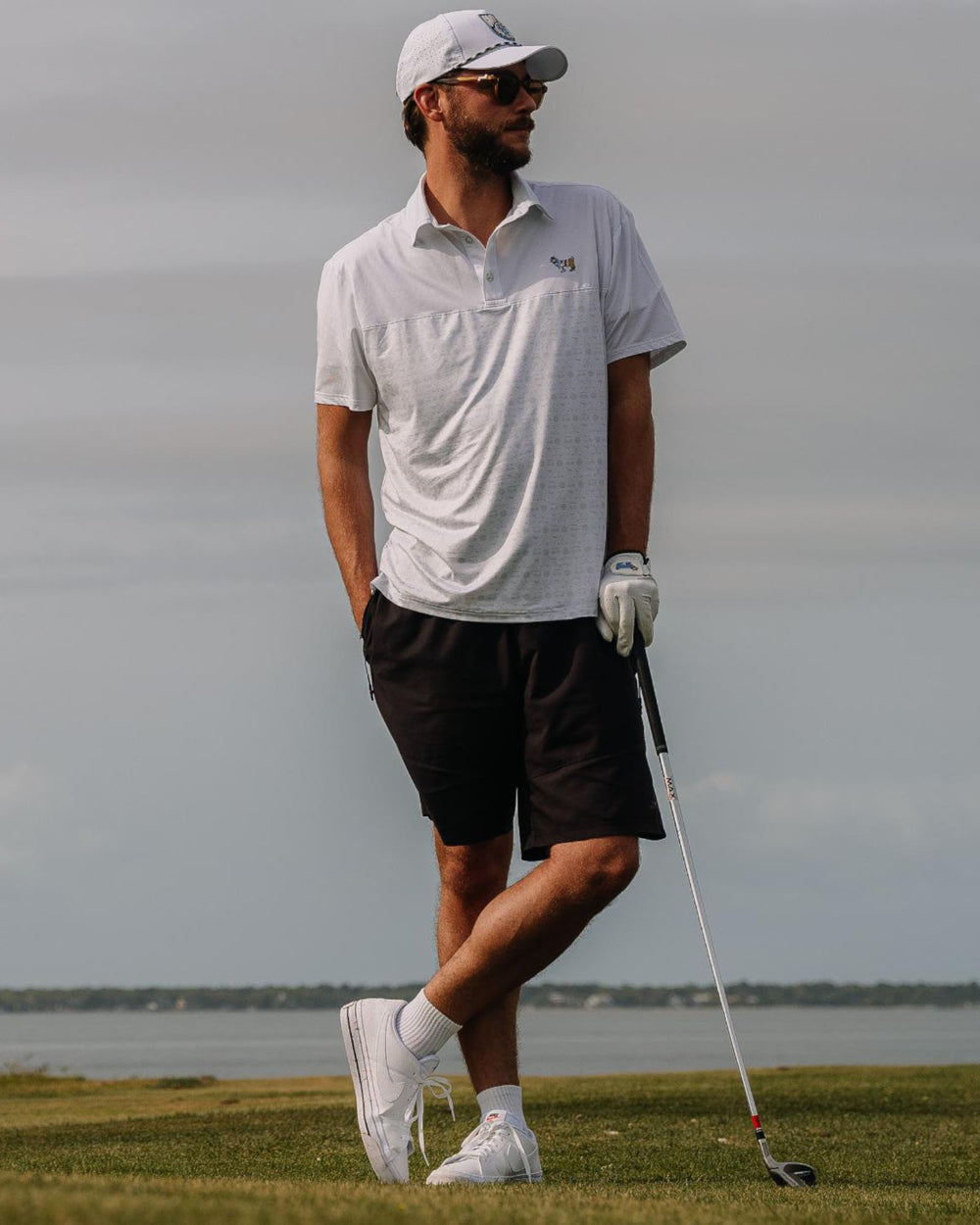 Man standing with golf club on golf course