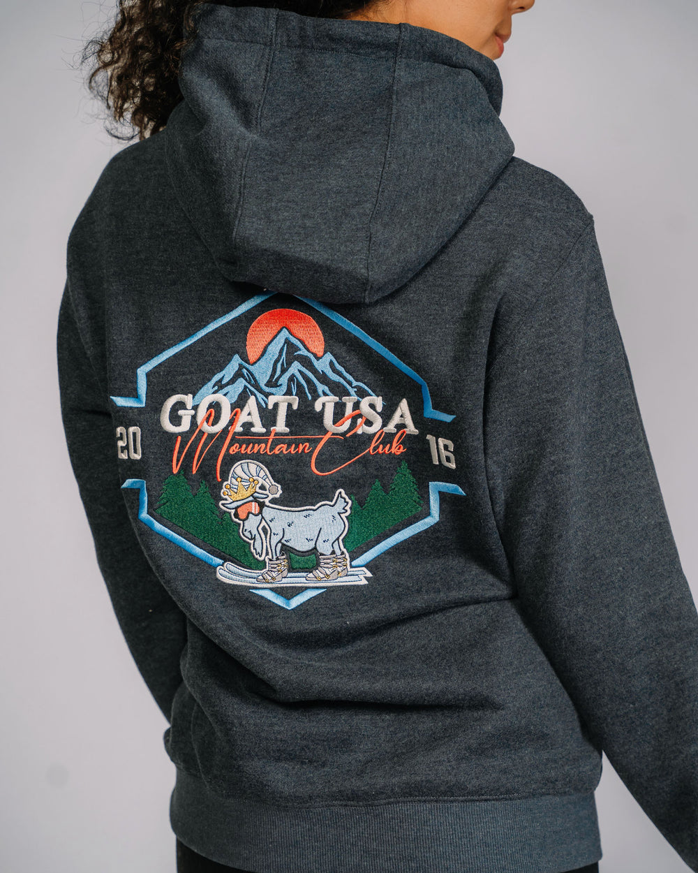 Back of GOAT USA mountain club hoodie with skiing goat in front of mountains