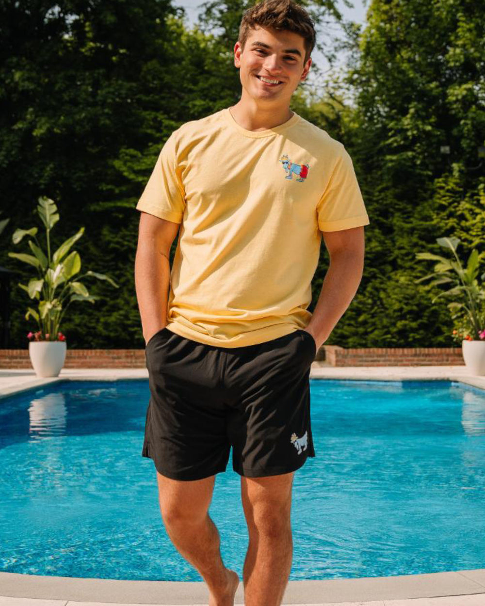 Guy standing in front of a pool#color_black